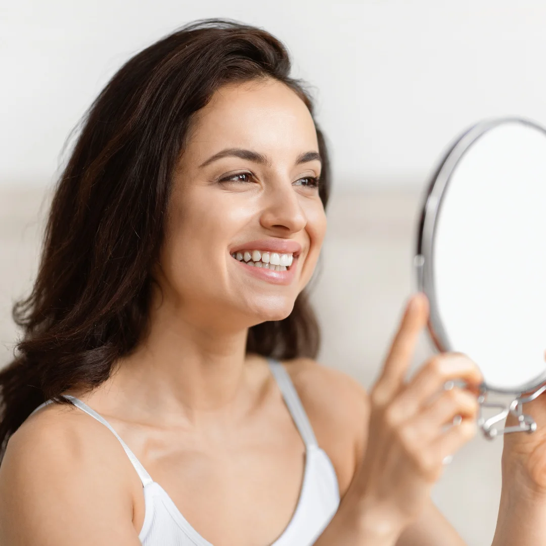Woman examining her lips in the mirror before cosmetic lip procedure